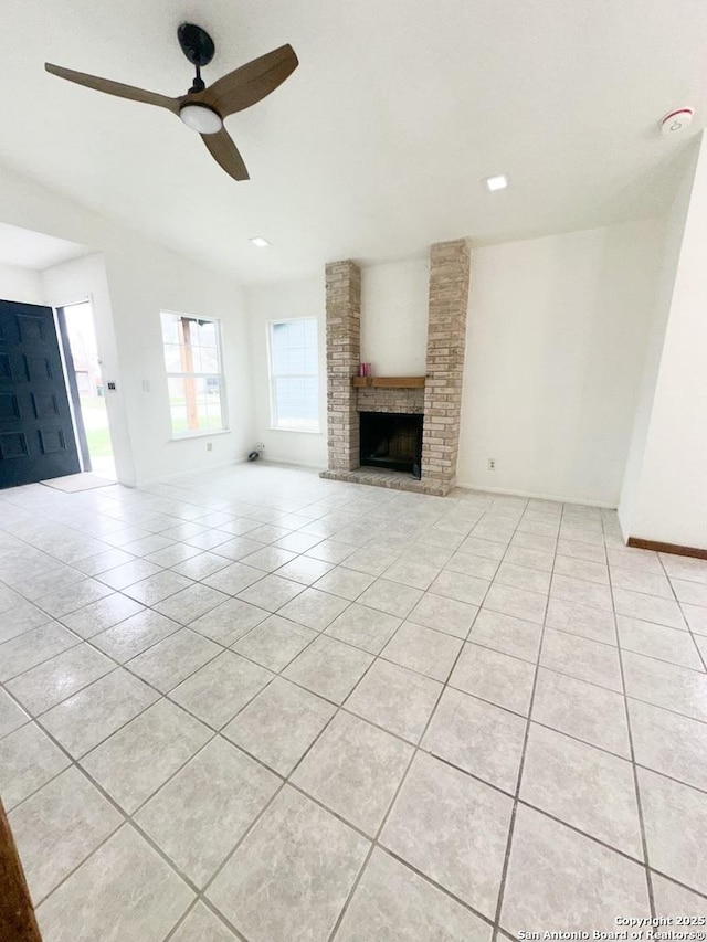 unfurnished living room with ceiling fan, light tile patterned floors, and a fireplace