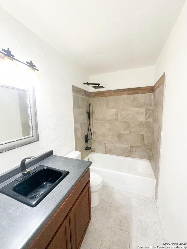 full bathroom with vanity, tiled shower / bath, tile patterned floors, and toilet