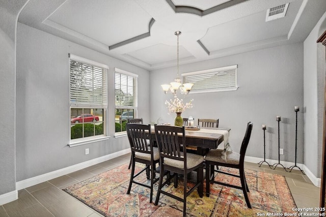 tiled dining area with coffered ceiling and a chandelier