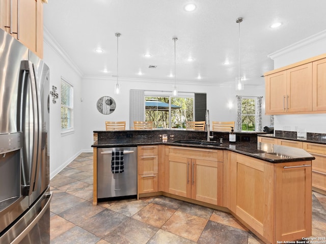 kitchen featuring appliances with stainless steel finishes, pendant lighting, and light brown cabinetry