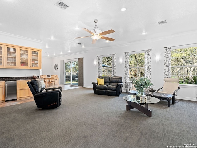 carpeted living room featuring crown molding, indoor bar, plenty of natural light, and ceiling fan