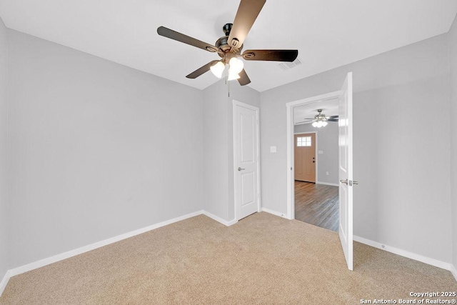 unfurnished bedroom featuring ceiling fan and carpet