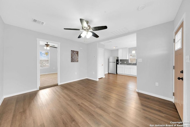 unfurnished living room featuring hardwood / wood-style flooring and ceiling fan