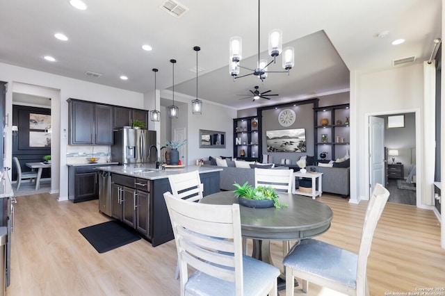 dining area featuring crown molding, sink, ceiling fan, and light hardwood / wood-style floors