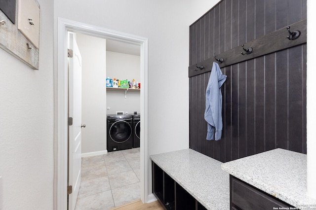 mudroom with light tile patterned flooring and independent washer and dryer