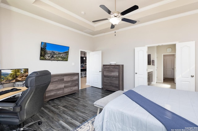 bedroom featuring dark hardwood / wood-style flooring, ornamental molding, a raised ceiling, and ceiling fan