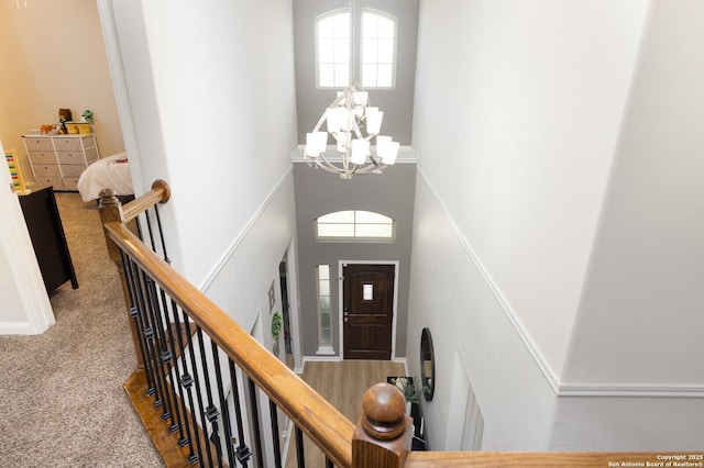 foyer with a notable chandelier, carpet floors, and a high ceiling