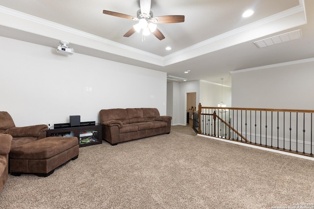 carpeted living room featuring a tray ceiling, ornamental molding, and ceiling fan