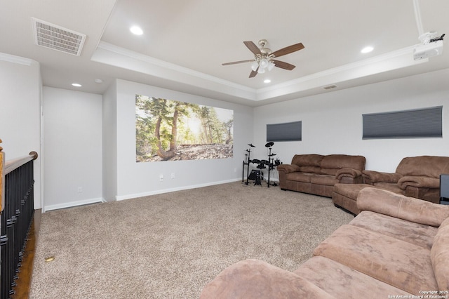 living room with crown molding, carpet flooring, and a raised ceiling