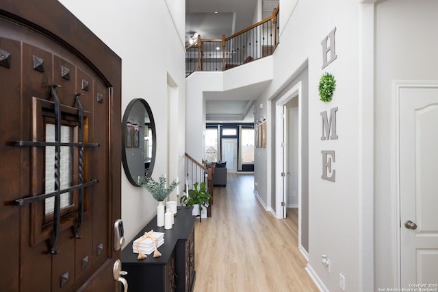 foyer entrance featuring a high ceiling and light wood-type flooring