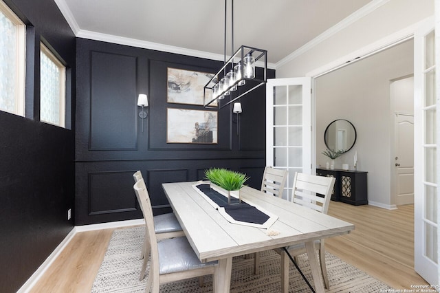 dining space with crown molding and light hardwood / wood-style flooring