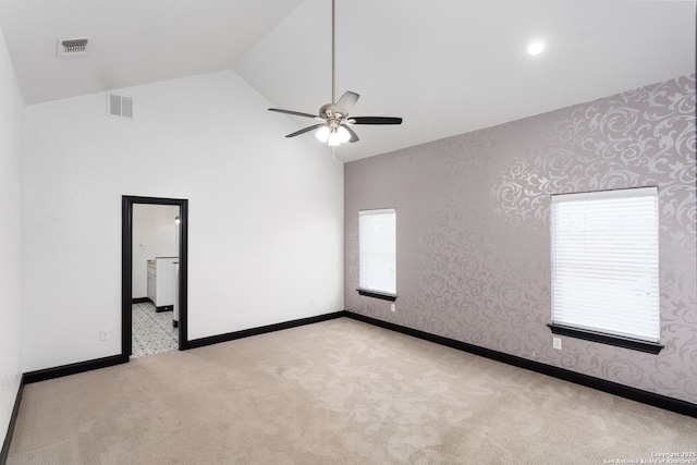 empty room featuring light carpet, high vaulted ceiling, and ceiling fan