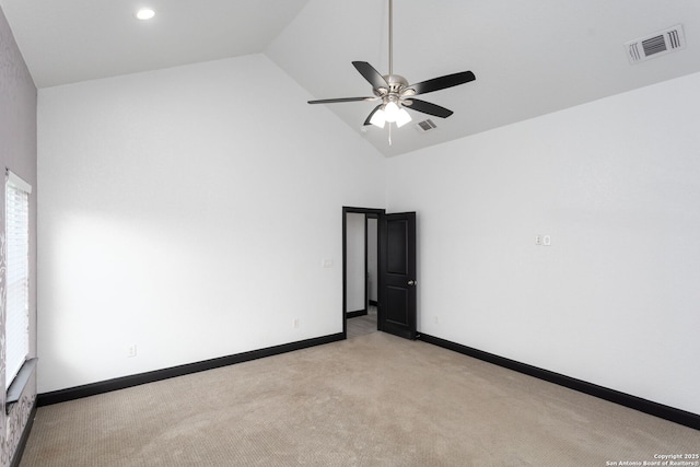 empty room featuring ceiling fan, light colored carpet, and high vaulted ceiling