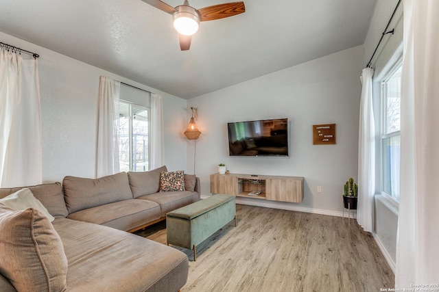 living room featuring ceiling fan, lofted ceiling, a wealth of natural light, and light hardwood / wood-style floors