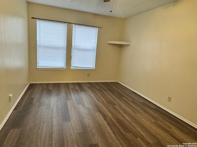 unfurnished room featuring ceiling fan, dark wood-type flooring, and a textured ceiling