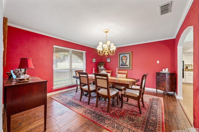 dining space featuring a chandelier, dark hardwood / wood-style flooring, and ornamental molding