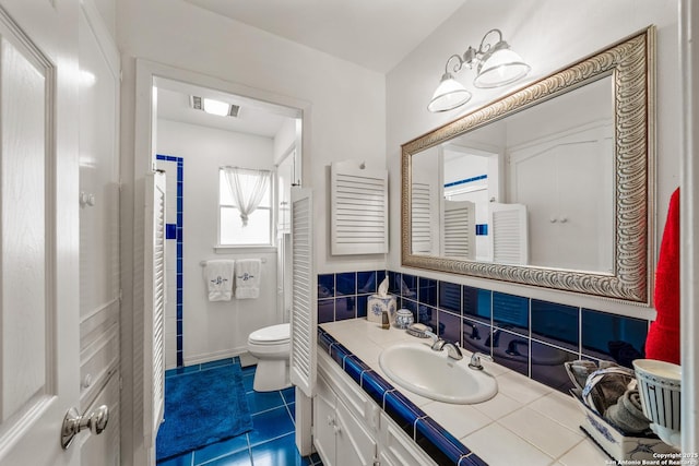 bathroom featuring decorative backsplash, vanity, tile patterned flooring, and toilet