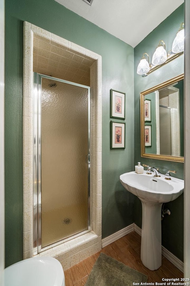 bathroom featuring toilet, hardwood / wood-style floors, and an enclosed shower