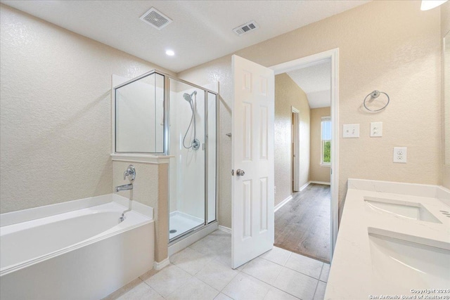 bathroom with tile patterned flooring, vanity, and separate shower and tub