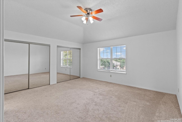 25002 Silverstone, San Antonio, TX 78258 - unfurnished bedroom with carpet floors, multiple closets, a ceiling fan, a textured ceiling, and lofted ceiling