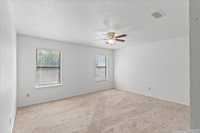25002 Silverstone, San Antonio, TX 78258 - empty room featuring a ceiling fan, healthy amount of natural light, carpet floors, and a textured ceiling