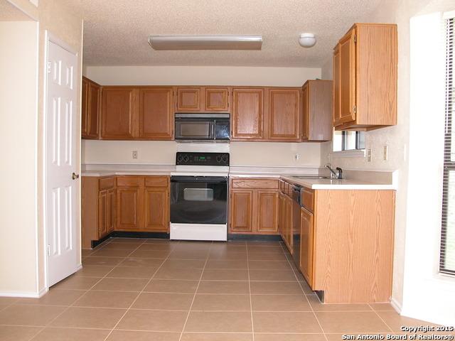 25002 Silverstone, San Antonio, TX 78258 - kitchen featuring electric stove, black microwave, light countertops, light tile patterned flooring, and a textured ceiling