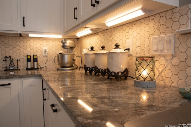 kitchen featuring white cabinetry, stone countertops, and decorative backsplash