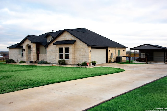 view of front facade featuring a garage, central AC, and a front yard