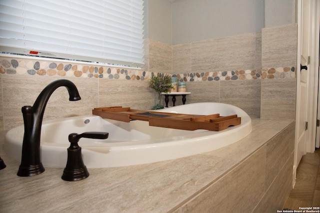 bathroom featuring sink and tiled bath