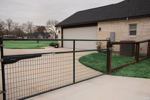 view of gate with a lawn