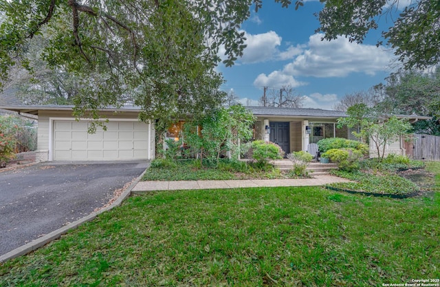 ranch-style home featuring a garage and a front lawn