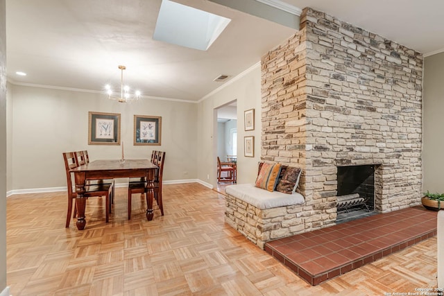 dining room featuring crown molding, an inviting chandelier, a skylight, a fireplace, and light parquet flooring