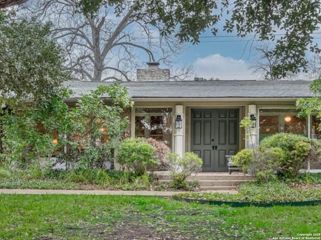 entrance to property featuring a lawn