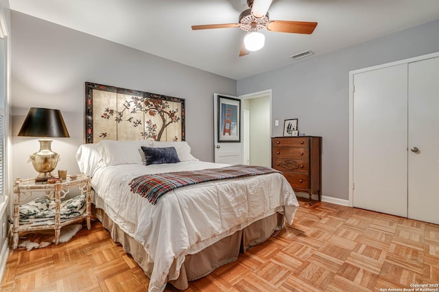 bedroom featuring ceiling fan, a closet, and light parquet flooring