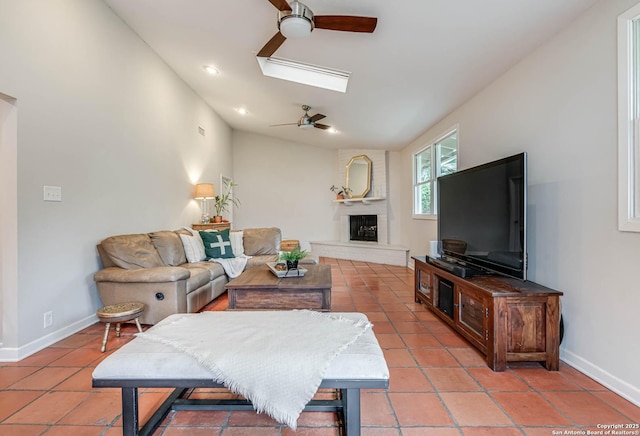 living room with light tile patterned flooring, ceiling fan, and a skylight