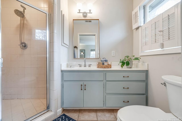 bathroom featuring an enclosed shower, vanity, tile patterned flooring, and toilet