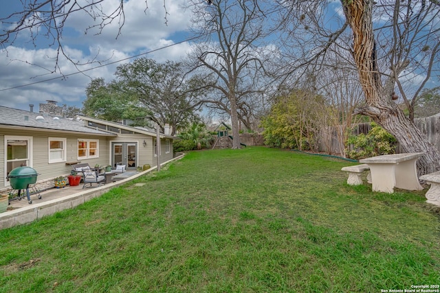 view of yard featuring a patio and french doors