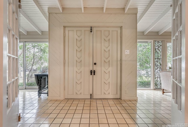 foyer featuring light tile patterned floors, beam ceiling, and wooden ceiling