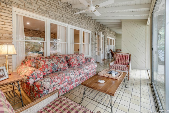 sunroom / solarium featuring beamed ceiling and ceiling fan