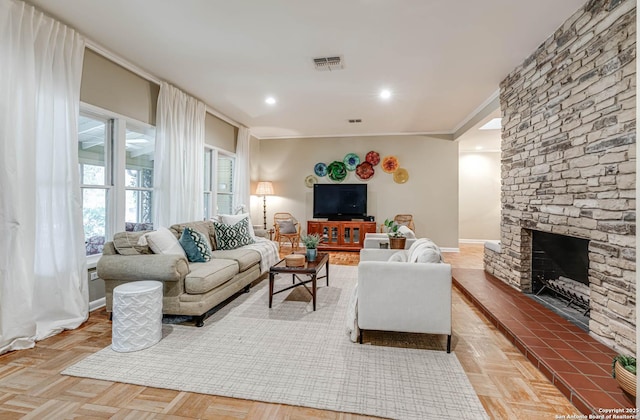 living room featuring parquet floors, ornamental molding, and a fireplace