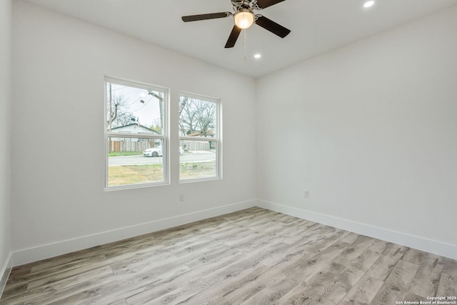 empty room with ceiling fan and light hardwood / wood-style flooring