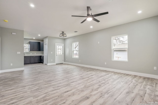 unfurnished living room with ceiling fan and light hardwood / wood-style floors