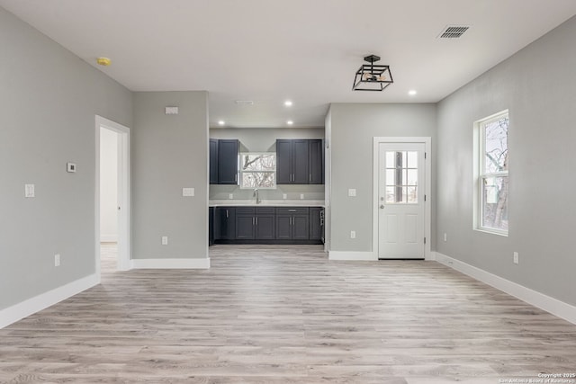 unfurnished living room featuring sink and light wood-type flooring