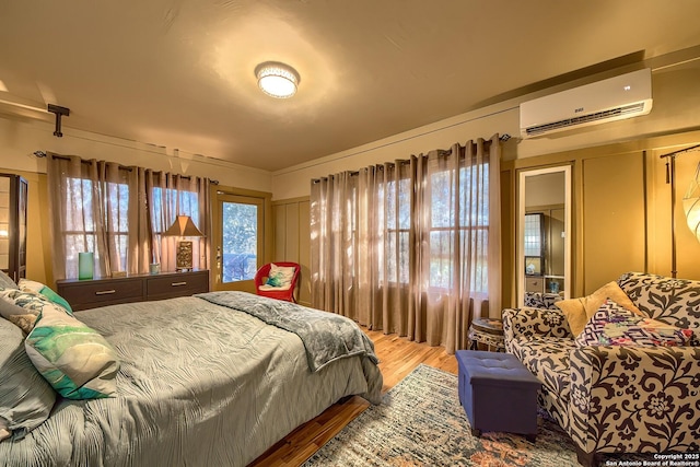 bedroom featuring hardwood / wood-style floors and a wall mounted AC