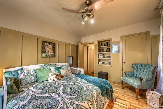 bedroom with ceiling fan, a textured ceiling, and light wood-type flooring