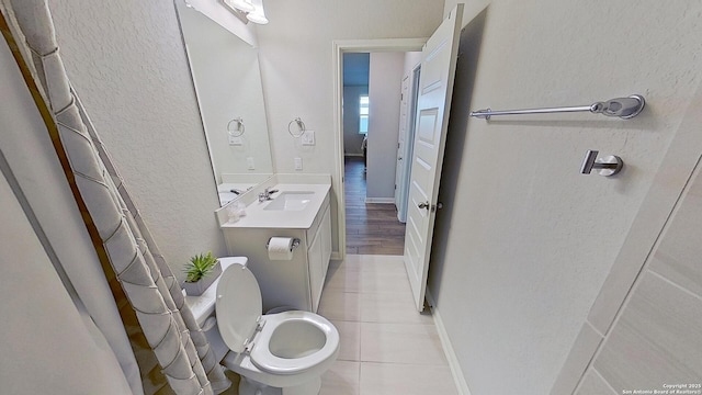 bathroom featuring vanity, tile patterned floors, and toilet