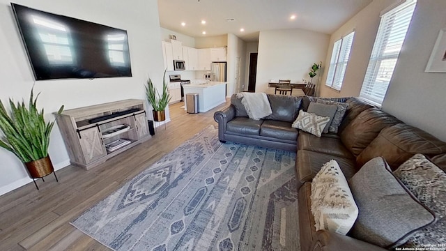 living room with lofted ceiling and light wood-type flooring