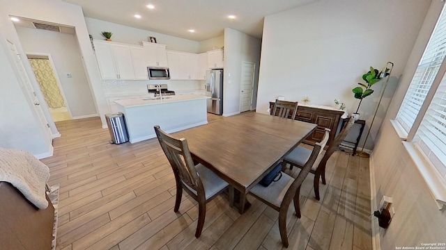 dining room featuring sink and light wood-type flooring