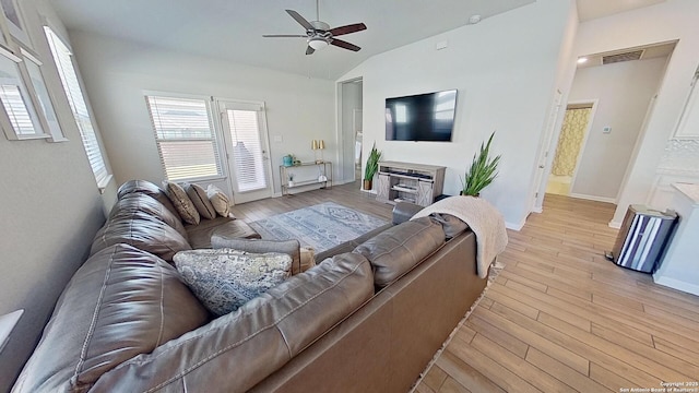 living room featuring vaulted ceiling, light hardwood / wood-style floors, and ceiling fan