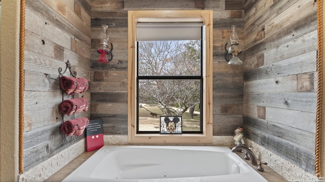 bathroom with a tub and wood walls